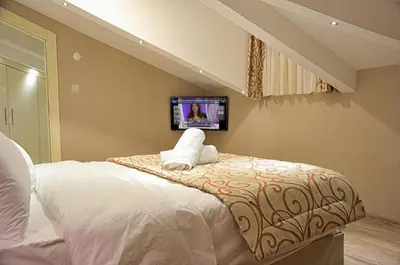 a bedroom with a bed with a tv on the wall at Best Fulya Suites in Istanbul