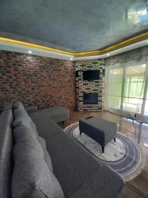 a living room with a couch and a brick wall at Sakarya Sapanca da Özel Havuzlu , Ailelere Özel Villalar in Sapanca