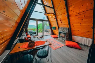 a room with a table and a fireplace in a tree house at Sakarya Sapanca Memnuniye de 3 Oda1 salon Özel Havuzlu-Jakuzili-Şömineli-Korunaklı 8 Kişilik Bungalov in Sapanca