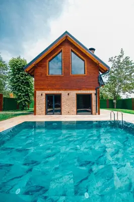 a house with a swimming pool in front of a house at Kartepe Maşukiye de 2 oda1 salon Özel Havuzlu - Şömineli -Muhafazakar 5 Kişilik Bungalov in Korfez