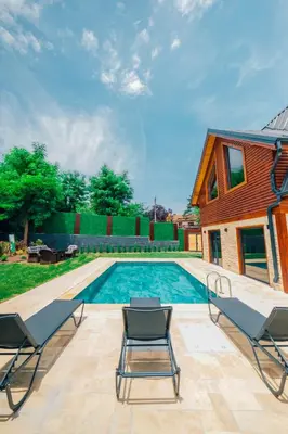 a swimming pool with chairs and a house at Kartepe Maşukiye de 2 oda1 salon Özel Havuzlu - Şömineli -Muhafazakar 5 Kişilik Bungalov in Korfez