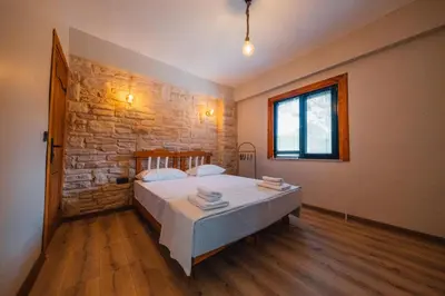 a bedroom with a large bed and a stone wall at Kartepe Maşukiye de 2 oda1 salon Özel Havuzlu - Şömineli -Muhafazakar 5 Kişilik Bungalov in Korfez
