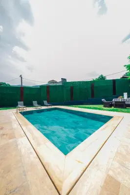 a swimming pool with blue water in a yard at Kartepe Maşukiye de 2 oda1 salon Özel Havuzlu - Şömineli -Muhafazakar 5 Kişilik Bungalov in Korfez