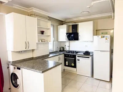 a kitchen with white cabinets and a washer and dryer at Apartment in Sisli Mado14 in Istanbul