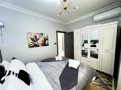 a bedroom with a large bed and a chandelier at Dream Apartment in Sheshli 5 4 1 in Istanbul