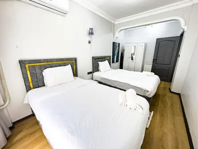 two beds in a small room with white sheets at Dream Apartment in Sheshli 5 4 1 in Istanbul