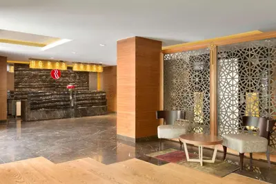 a lobby with a table and chairs in a building at Ramada by Wyndham Gemli̇k in Gemlik