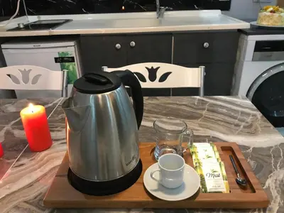 a tea kettle on a table with a candle and a cup at Nexus By Taksim Hotel in Istanbul