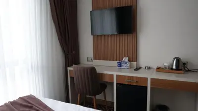 a hotel room with a desk with a television on it at Karadeniz Hotel Çorlu in Corlu
