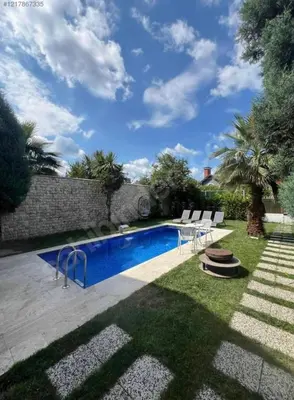a swimming pool with chairs and a table in a yard at Villa Luna Sapanca in Sakarya