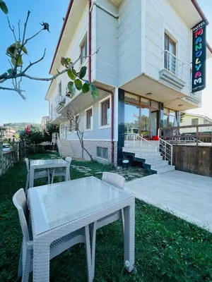 a white table and chairs in front of a building at Ağva Manolyam Otel in Sile