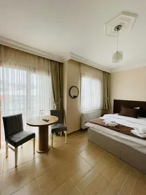 a bedroom with a bed and a table and chairs at Ağva Manolyam Otel in Sile
