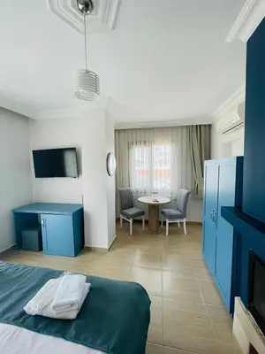 a bedroom with a bed and a table in a room at Ağva Manolyam Otel in Sile