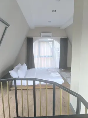 a bed with white sheets and pillows in a room at Hilloria Tatil Köyü in Sapanca