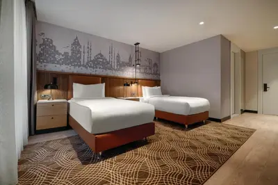 a bedroom with two beds and a rug at Tryp by Wyndham Istanbul Beyoglu in Istanbul