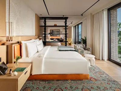 a bedroom with a large white bed and a living room at Aliée Istanbul - A Paris Society Collection Hotel in Istanbul