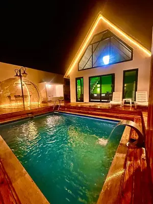 a swimming pool in front of a house at night at Bigados Otel & Bungalov in Silivri