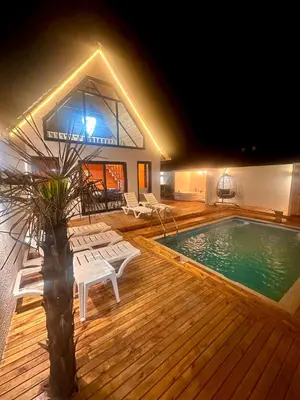 a house with a swimming pool and a deck with chairs at Bigados Otel & Bungalov in Silivri