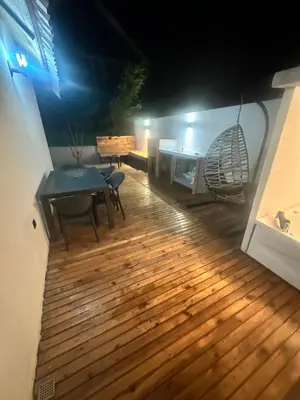 a wooden deck with a table and a bench at Bigados Otel & Bungalov in Silivri