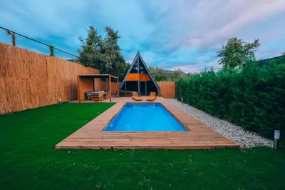 a backyard with a swimming pool and a wooden deck at Maya Sapanca Bungalow in Sapanca