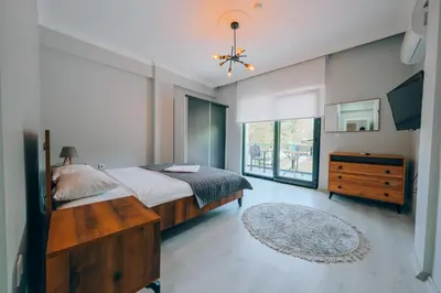 a bedroom with a bed and a dresser and a window at Villove Sapanca in Sapanca