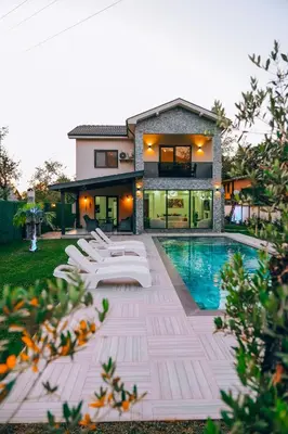 a house with a swimming pool and white lounge chairs at Villove Sapanca in Sapanca