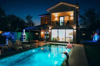 a swimming pool in front of a house at night at Villove Sapanca in Sapanca