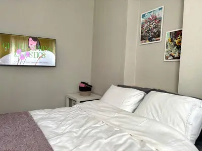 a bedroom with a bed with white sheets and posters at Pink House - Central Location by Seashore, Fiber Internet in Istanbul