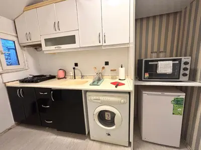 a small kitchen with a washing machine and a microwave at Pink House - Central Location by Seashore, Fiber Internet in Istanbul