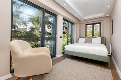 a bedroom with a bed and a chair and windows at Luxury Stay with Panoramic Bosphorus View in Istanbul