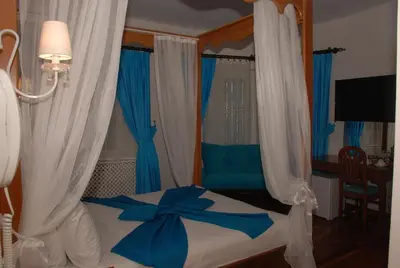a bedroom with a bed with blue and white curtains at Mavi Inci Park Otel in Erdek