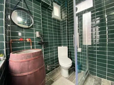 a green tiled bathroom with a toilet and a barrel at Hendec 7 Apartments Near Galataport in Istanbul