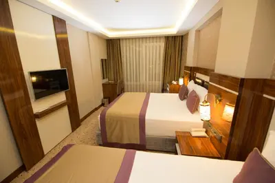 a hotel room with two beds and a television at Ruba Palace Thermal Hotel in Bursa