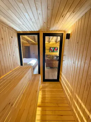 a sauna with a bed and a glass door at Navy Inn & Bungalows in Arnavutköy