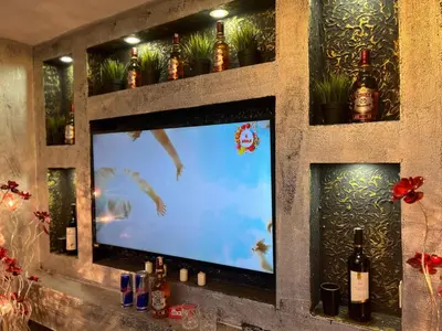 a television in a wall with bottles and plants at HEVİN Otel in Bursa