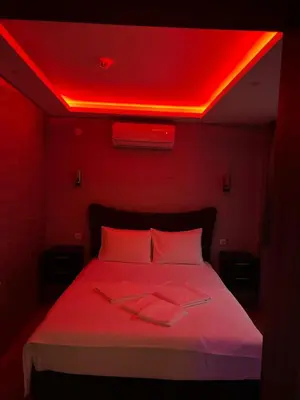 a bedroom with a bed with red lights on it at HEVİN Otel in Bursa
