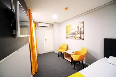 a room with a bed and two chairs and a table at Polo Suit Otel in Avcılar