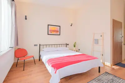 a bedroom with a large bed and a red chair at Casa Nozze 3 in Istanbul