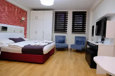 a bedroom with a bed and two blue chairs at Taksim green suite in Istanbul