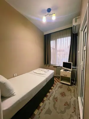 a small bedroom with a bed and a window at Fındık Palas Otel in Istanbul