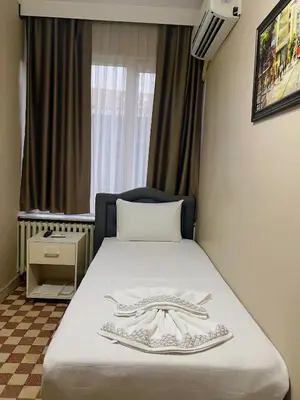 a hotel room with a bed with a robe on it at Fındık Palas Otel in Istanbul