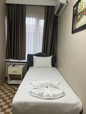a hotel room with a bed with a robe on it at Fındık Palas Otel in Istanbul