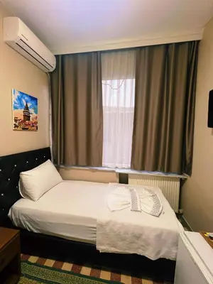 a small bedroom with a bed and a window at Fındık Palas Otel in Istanbul