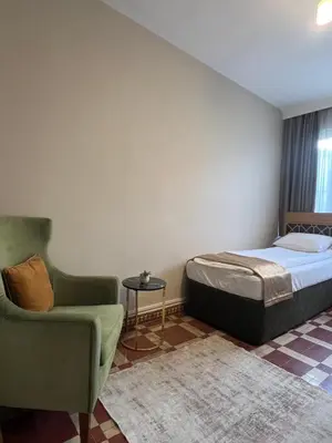 a bedroom with a bed and a chair at Fındık Palas Otel in Istanbul