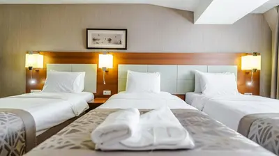 two beds in a hotel room with towels on them at Kent Hotel Beyazıt in Istanbul