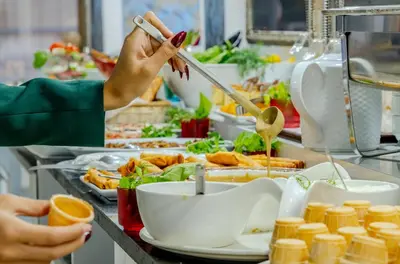a person preparing food in a buffet line at Peak Star Hotel in Istanbul