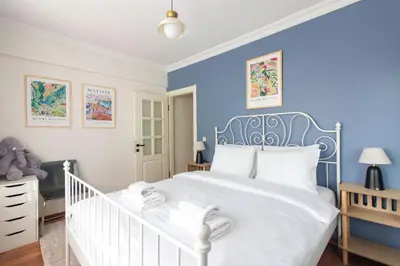a bedroom with a white bed and blue walls at Chic 2BR Gem on Moda Iconic Antiques Street in Istanbul