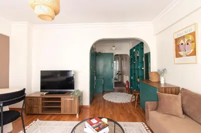 a living room with a couch and a tv at Chic 2BR Gem on Moda Iconic Antiques Street in Istanbul