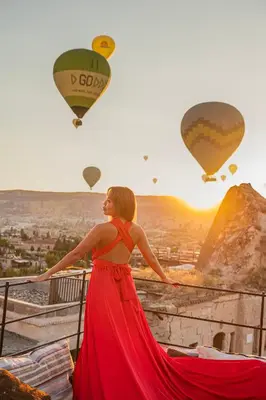 a woman in a red dress looking at hot air balloons at Zenith Göreme in Istanbul