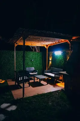 a wooden pergola with two benches under it at night at Mert Bungalov-Ay Evi in Sapanca